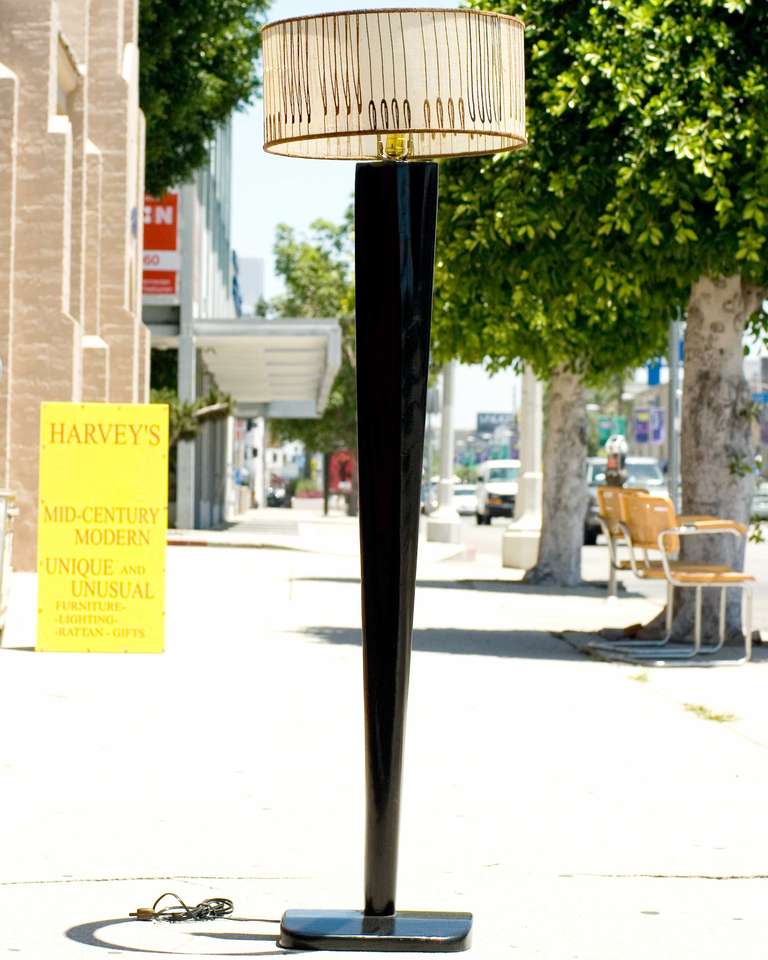 Beautiful black lacquer Heywood Wakefield floor lamp. The elegantly tapered body of the lamp is crowned with a spun fiberglass drum shade. Unique vintage touches can be seen throughout the drum shade.