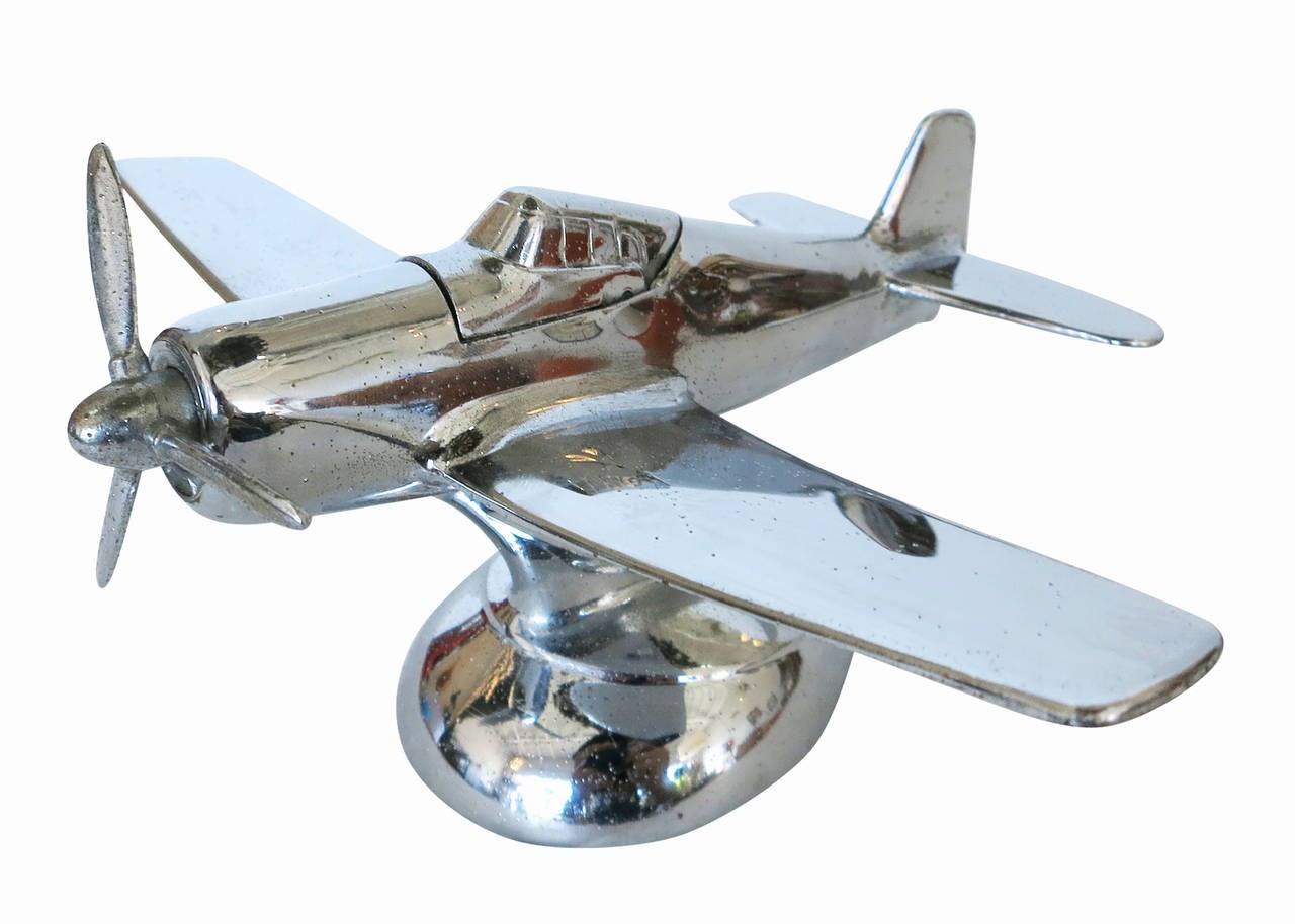 Post-war desktop airplane lighter modeled after the North American P-51A Mustang fighter plane used heavily in WWII. This lighter possesses a chrome plated metal body and modernist design. The lighter is unique in that it is a slightly more literal
