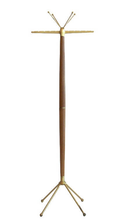 This mid-century modern Italian standing coat rack features a walnut body enhanced with playful 