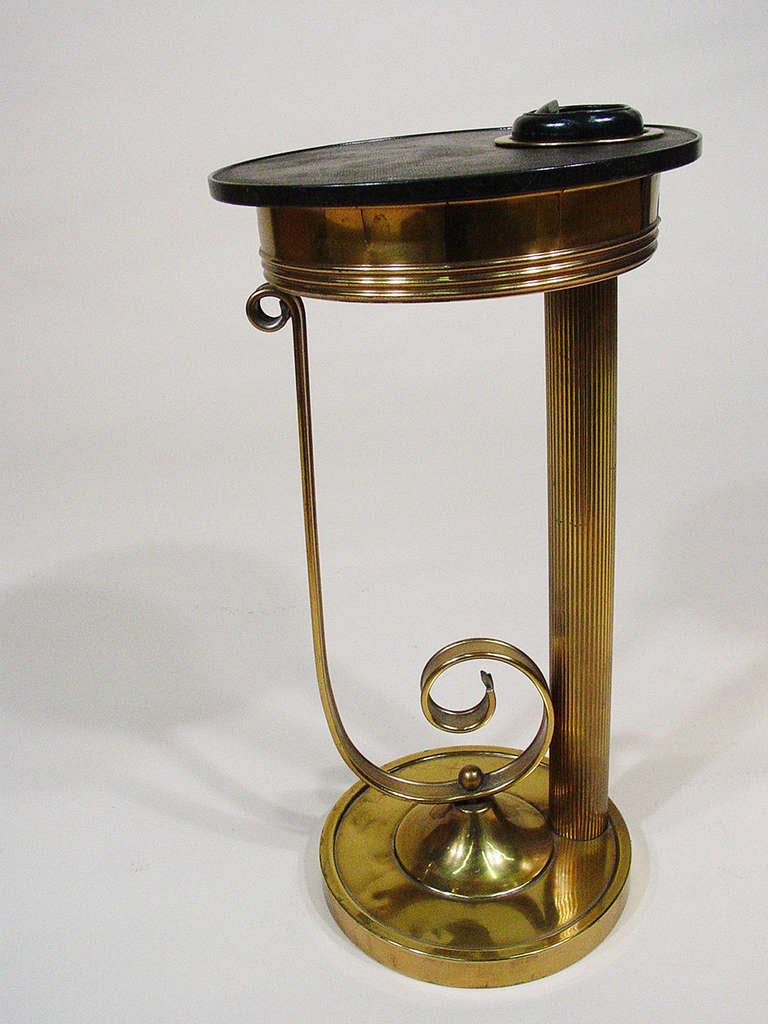 Original Walter Von Nessen Brass and Laminate Lazy Boy Smoker's Stand designed for the Chase Brass Company circa 1932. The smoking stand has a spherical retractable inset ashtray with black laminate swivel top  that when open reveals an interior