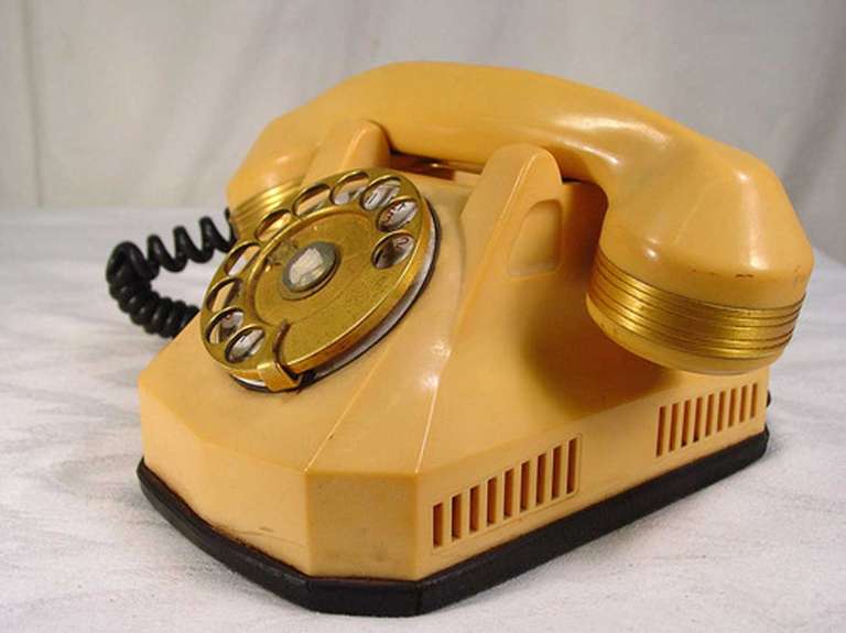 1930s White Catalin (colored Bakelite) Mono-phone Telephone with gold plate accents and a wonderful Art Deco style. It comes complete with all original parts, the cord has been modified to fit a modern wall jack.