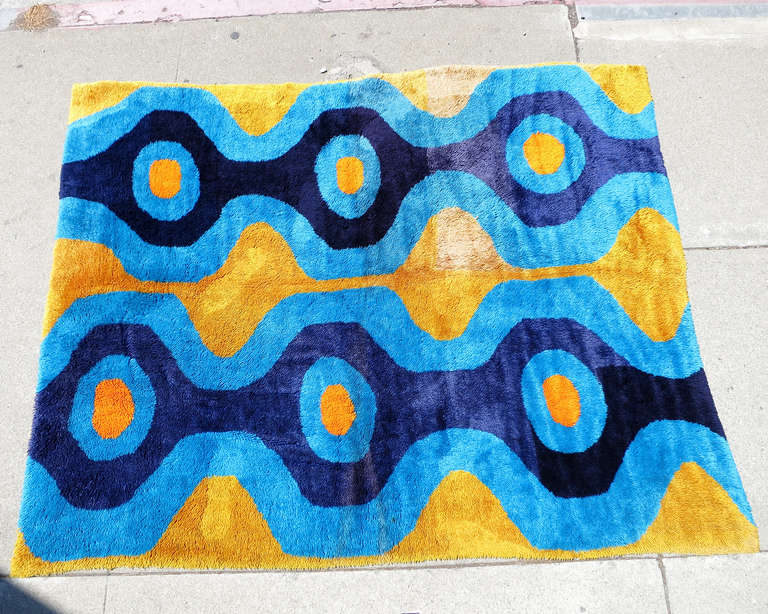 Large California 7' hand hooked area rug with blue and yellow Abstract hour glass pattern. This early 70s rug would work well in mod and any Post Modern setting.