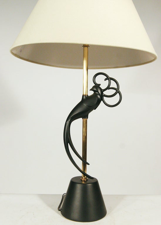 This pair of Mid-Century Modern table lamps by the Rembrandt Company features a sinuous lovebird rendered in iron attached to the brass stem. The lamps retain their original glass shades but have also been outfitted with flared linen ones.