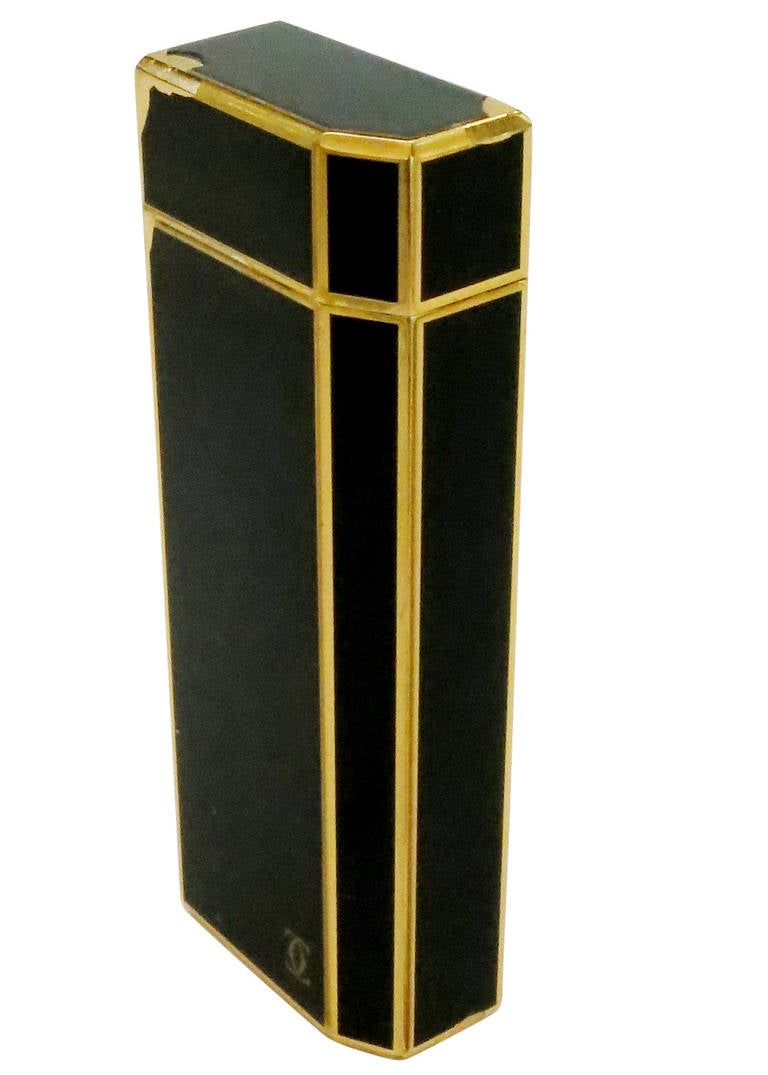 18k gold plate and black enamel Cartier lighter featuring a rectangular body with beautiful black enamel inlay with gold border. Interlocking 