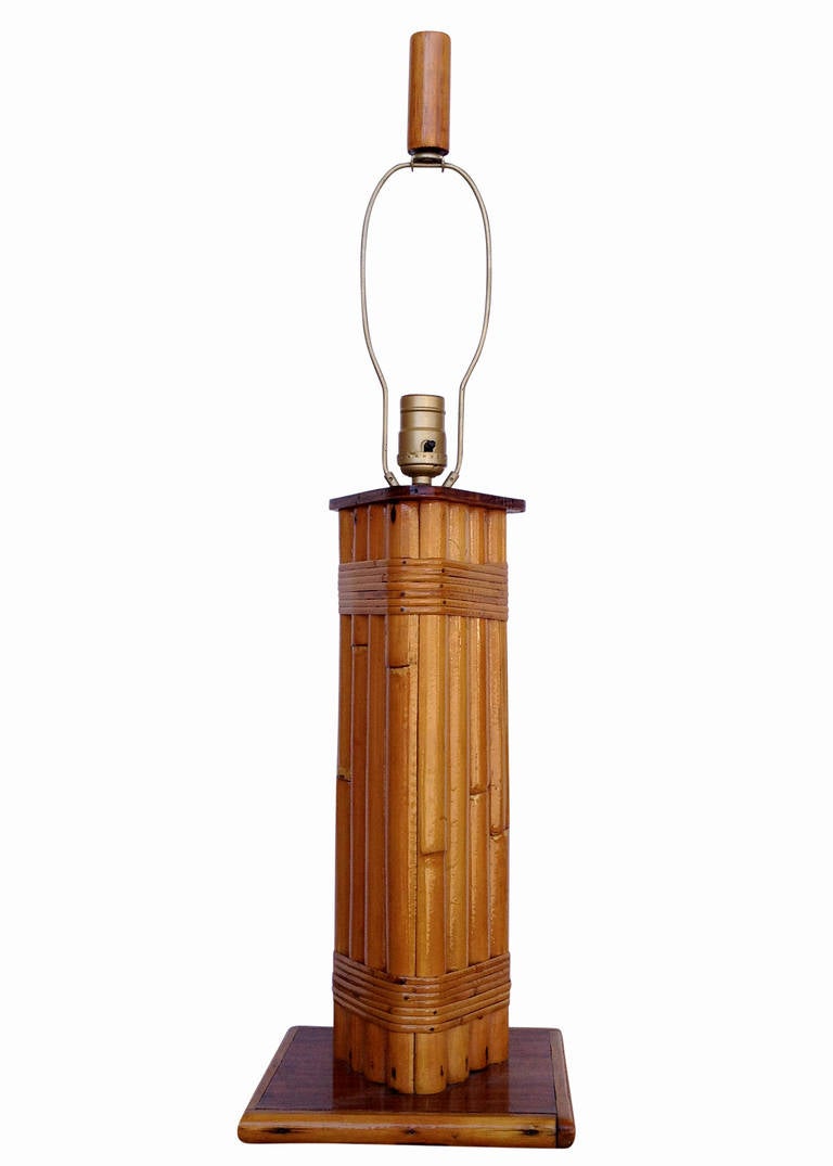 Wrapped rattan pole lamp with square mahogany base and top triangular shaped cap piece.

Restored to new for you.

All rattan, bamboo and wicker furniture has been painstakingly refurbished to the highest standards with the best materials. All