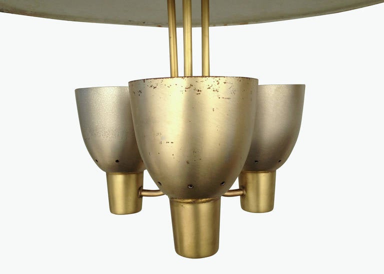 Mixed metal Gerald Thurston designed pendant with three aluminum shaded lights and reflector dome shield with brass stems and necks. Manufactured by Lightolier this pendant shows a heavy influence from the Southern California Googie architectural