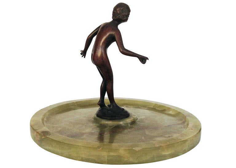 Designed circa 1920, this German-made bronze figural ring tray features a bronze cast nude nymph. The figure is fixed to a rounded green onyx tray for easy storage of rings and/or small jewelry. 

Signed 