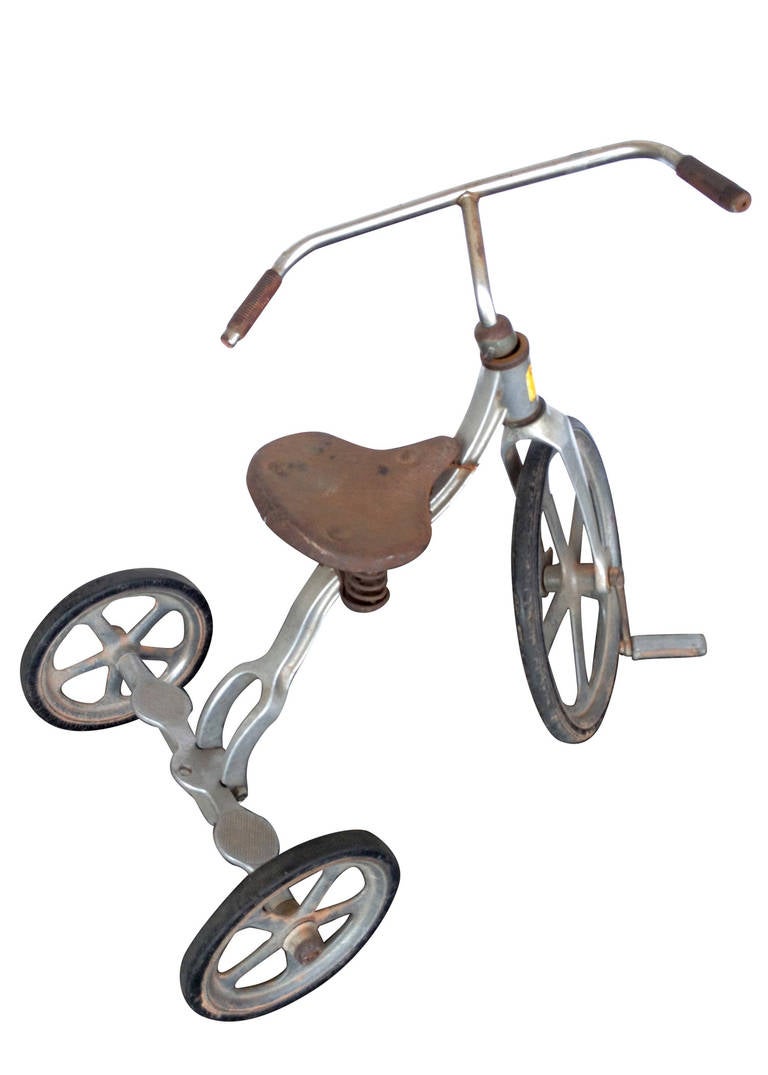 Designed by Anthony Brothers, this early post-war aluminum tricycle has the ability to convert from a tricycle to a bicycle by removing the bolts on the back wheels. 

This tricycle also comes with a nice patina, perfect for the rustic decor of a