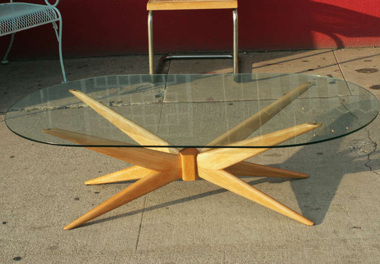 Impressive coffee table with a free formed base of bleached walnut supporting oval glass top. The table greatly resembles the form made famous by Paul Laszlo.