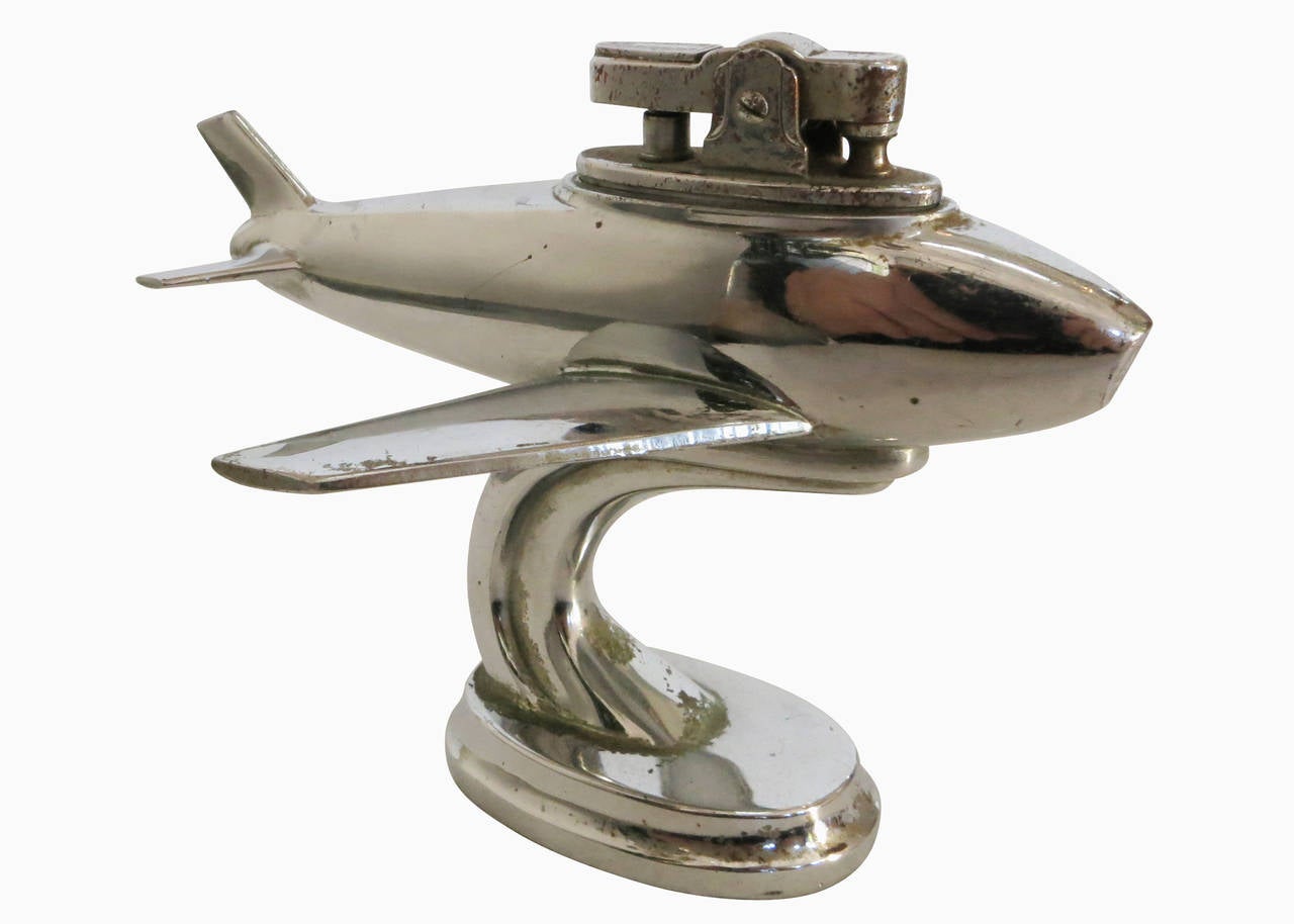 Post war jet airplane table lighter featuring a chromed spelter metal Jet liner with a pull out lighter by Ruby. The plane features the engraving 