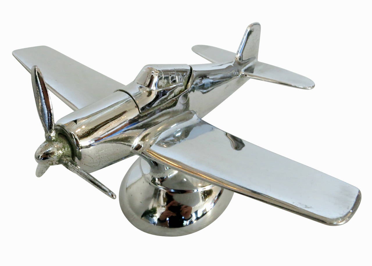 Post War desktop airplane lighter modeled after the North American P-51A Mustang fighter plane used heavily in WWII. This Lighter features a chrome plated metal body and simply modernist design with a slightly more literal interpretation of the