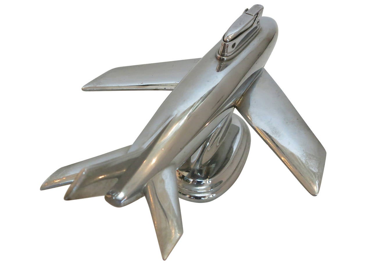 Post war jet airplane table lighter featuring a chromed spelter metal jet liner with a pull-out lighter by Ruby. The plane has a stamp along the light 