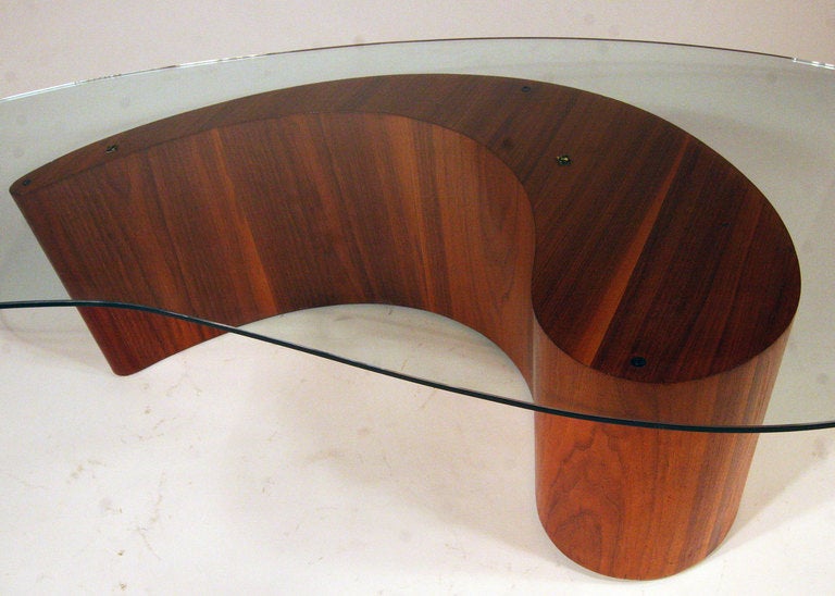 This 1960s cocktail table by Vladimir Kagan features a sculptural apostrophe or comma shaped, walnut base topped with a larger biomorphic piece of glass.