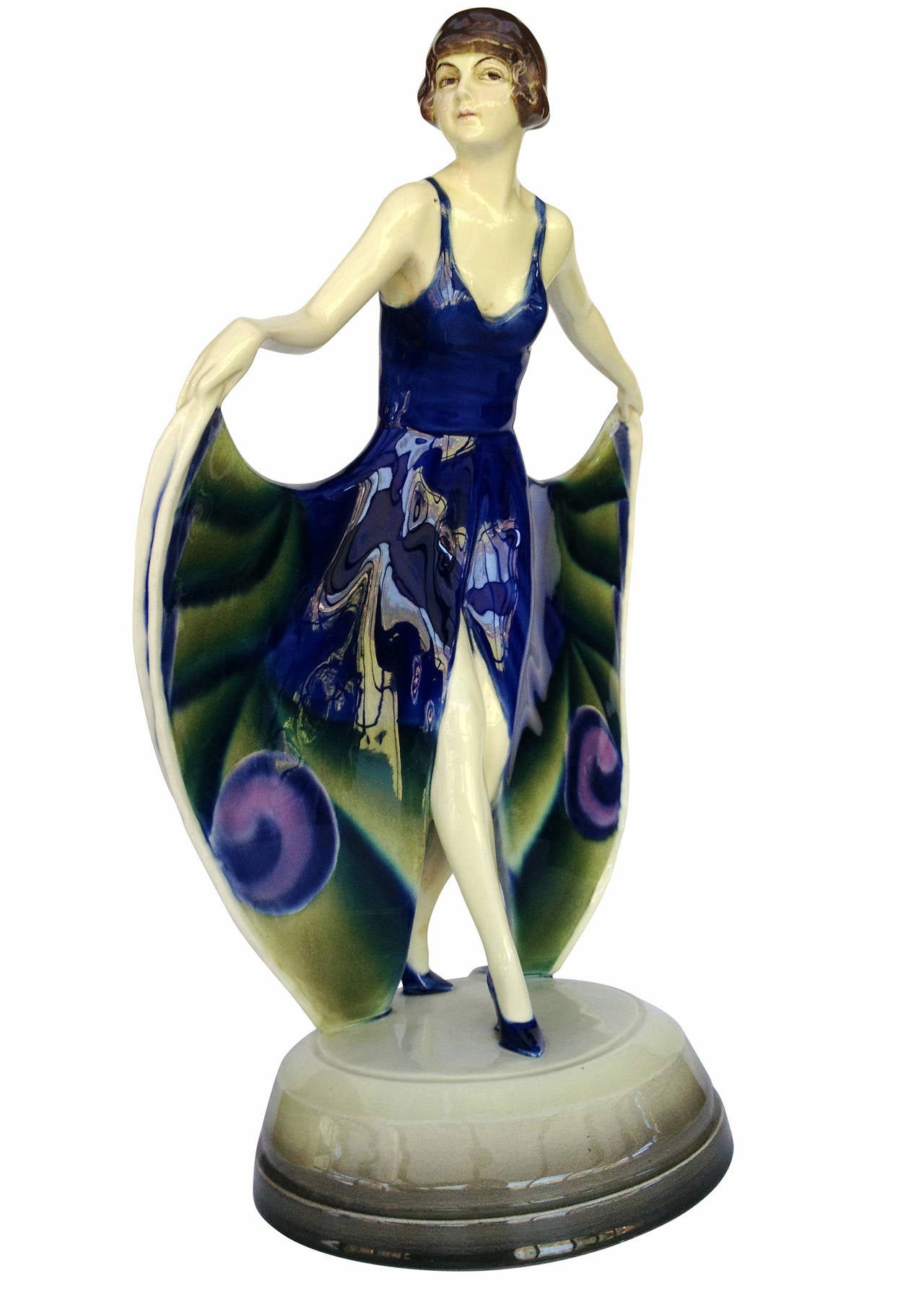 Josef Lorenzl ceramic statue featuring a female flapper with peacock dress giving a curtsy to onlooker. The statue is made by Austrian maker Goldscheider in 1925. It is signed by Josef Lorenzl with 