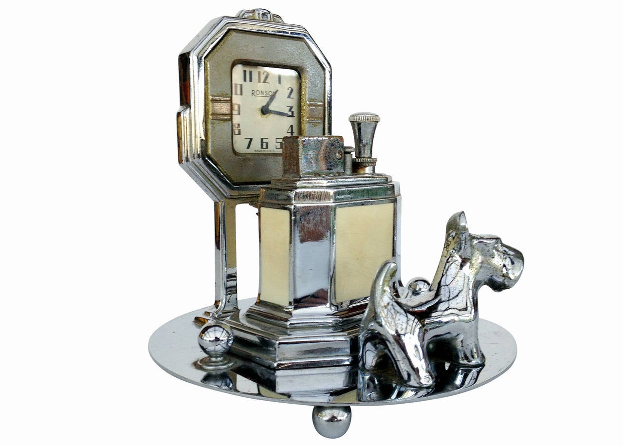 This rare Ronson tabletop lighter set, made circa 1935 features the well-known octette touch tip lighter with a unique base. The base features a clock tower and small 