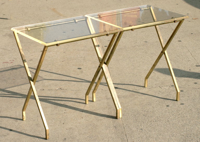 This pair of folding tray tables by Charles Hollis Jones feature unique removable Lucite tops with elegantly articulated brass legs.
