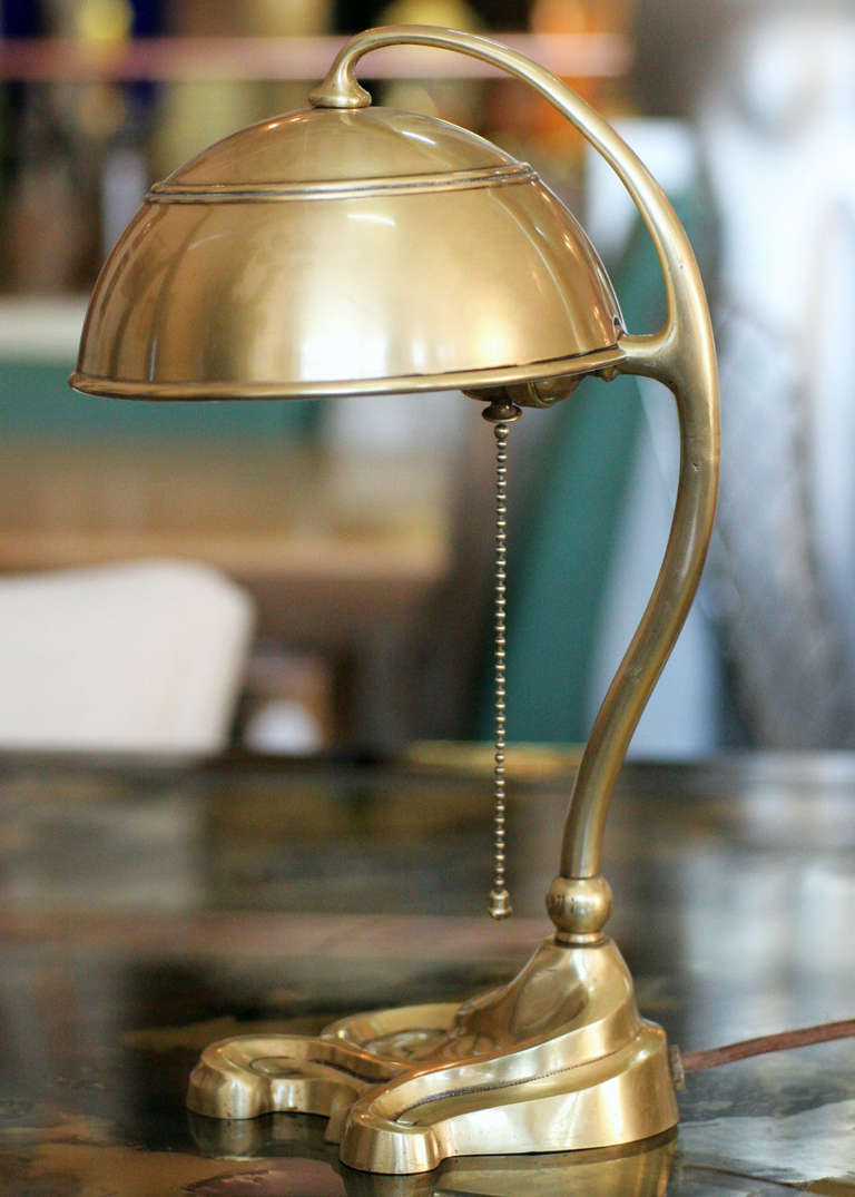 Bradley and Hubbard solid brass electric desk lamp with original brass shade. This lamp shows a heavy Art Nouveau influenced shape and design that meets to a beautiful scrolling base. Lamp have been polished and rewired with a cloth cord.  

The
