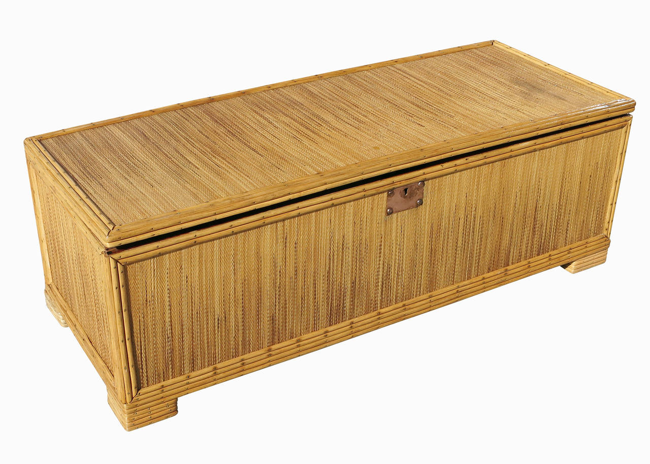 Made circa 1930, this stick rattan storage trunk with grass mat cover and solid cedar inner walls also comes with a unique copper face lock in the front. All decorative accents are finished with brass nails. 

Also available are a matching sofa,