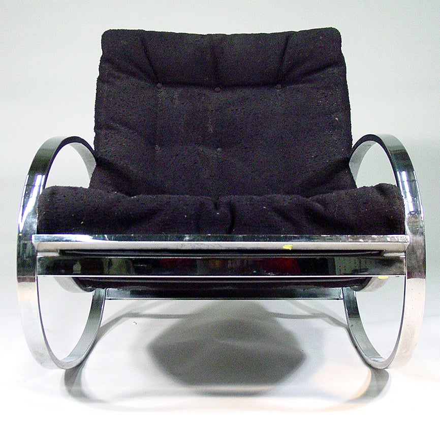 Circa 1970 Rocking chair features an elliptical chrome frame supporting the original black tufted black upholstery.
