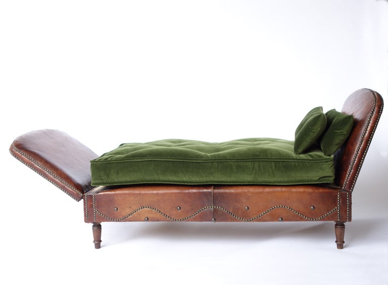 We love these settees, so we snap them up wherever we see them. This particular daybed has a fine patina. We are particularly taken by the marvelous sense of motion created by the nail-head decoration beneath the cushion.The arms are adjustable, and