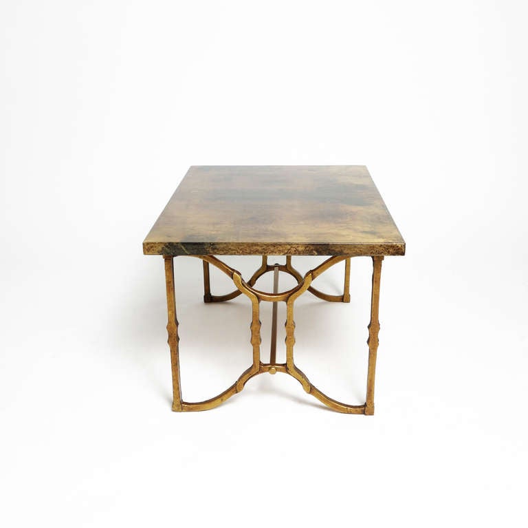 A small and stylish table designed by Aldo Tura, the lacquered goat skin top a mottled cognac color, the base of gold-patinated steel. Labeled.