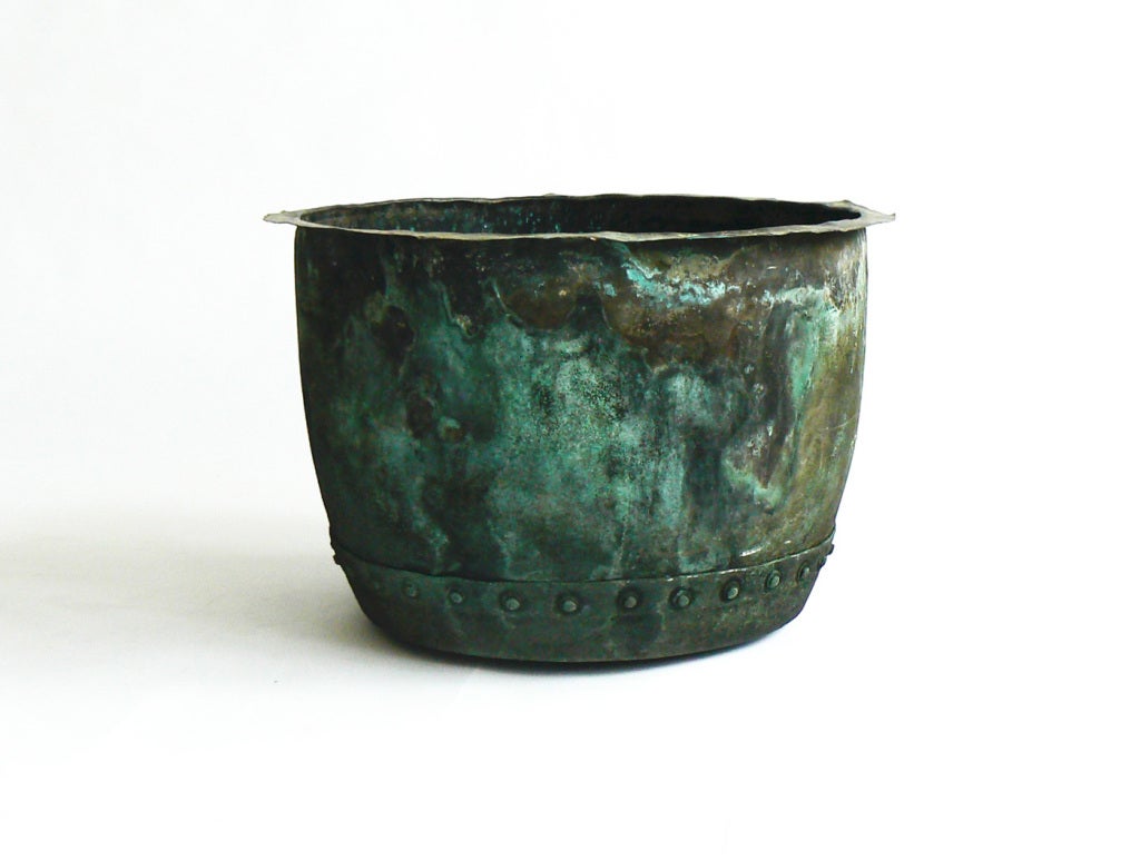 This is a typical example of the riveted copper boilers that were used on English farms in the 19th century. They have become sought-after planters because of the verdigris patina that they develop and for their versatility. What appear to be dents