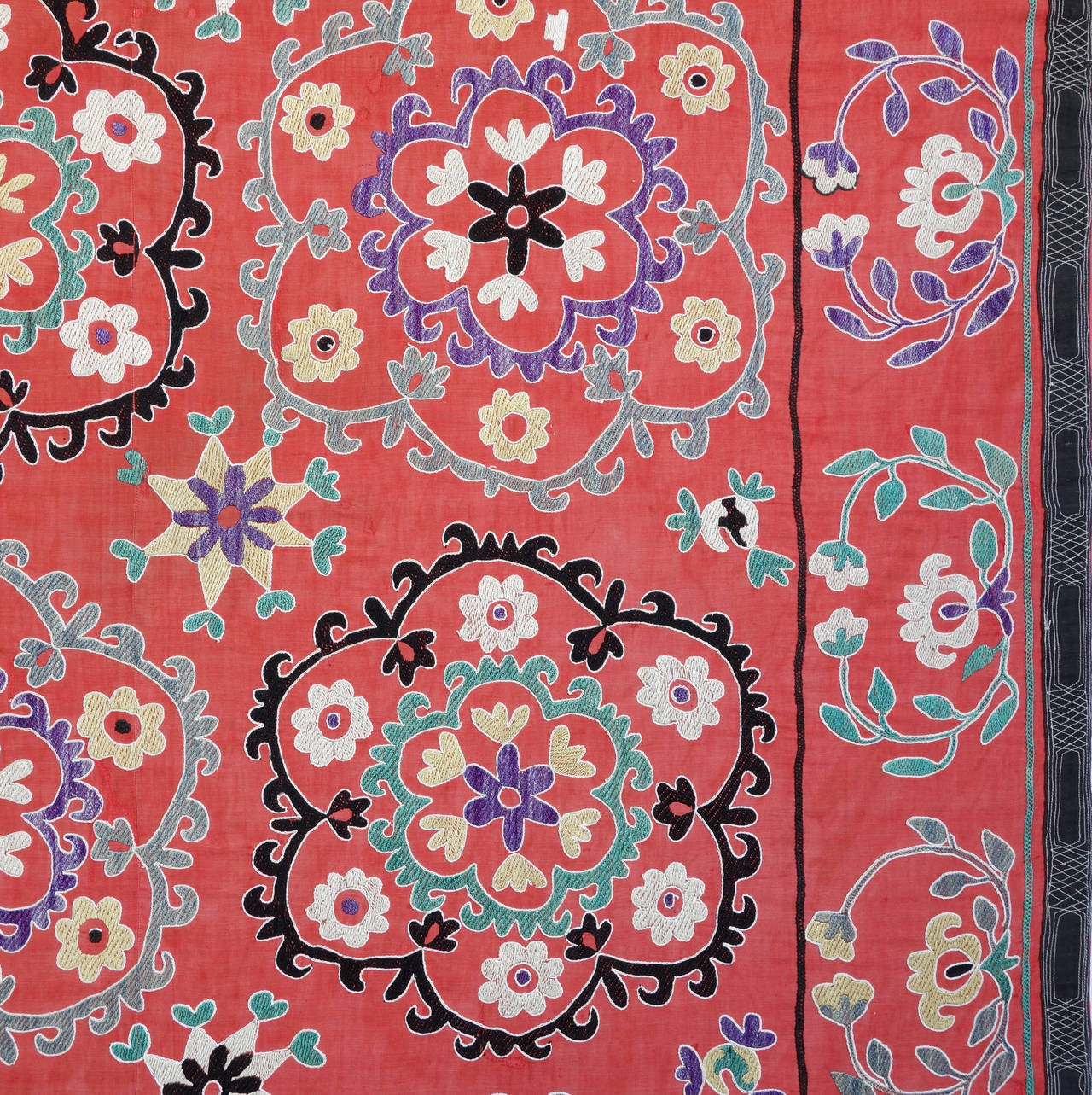 Suzanis were traditionally made by Central Asian brides as part of their dowry and presented to the groom on their wedding day. This is a wonderfully graphic example, with 16 large floral medallions alternating between black and green and purple and
