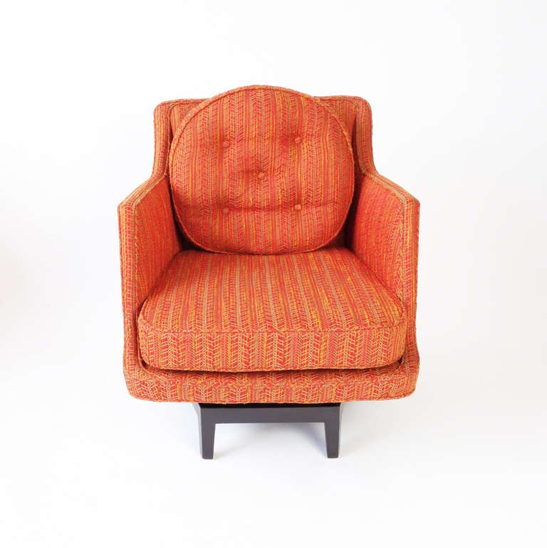 A 1960s Dunbar swivel armchair designed by Edward Wormley. The original upholstery, a reddish-orange weave the color of paprika, is in excellent condition (there is some subtle fading to the sides due to sun exposure). The base is ebonized mahogany.