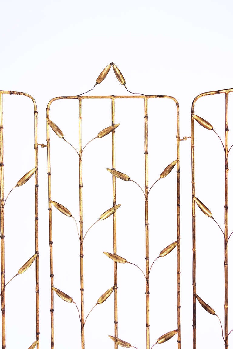 Three panels each comprised of five leafy, gilt iron stems of bamboo, joined with gilt iron hinges. An airily graceful ornament attributed to Maison Bagues.