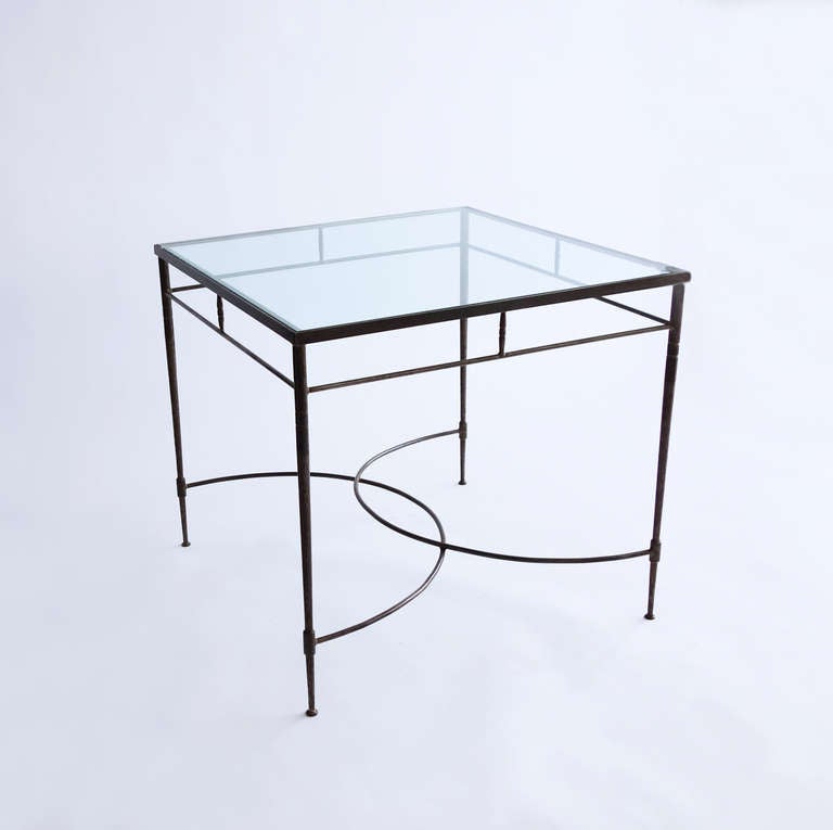 This table would reside happily indoors or out. The design details are thoughtful, and create an elegant effect: the subtly tapered legs flaring out again at the feet, the hammered surface of the legs, the overlapping demilune stretchers, the
