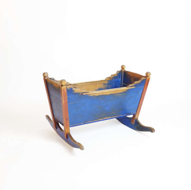 This is a generously sized cradle with a sculptural presence, perfect for storing woolen blankets or armloads of toys. The wood's warm tones are revealed where hands have worn away the beautiful Swedish blue.

Width of the opening is 18