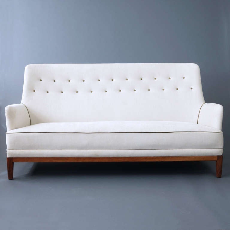 A very elegant Swedish moderne sofa upholstered in a pale sand-colored chenille with green leather trim.
