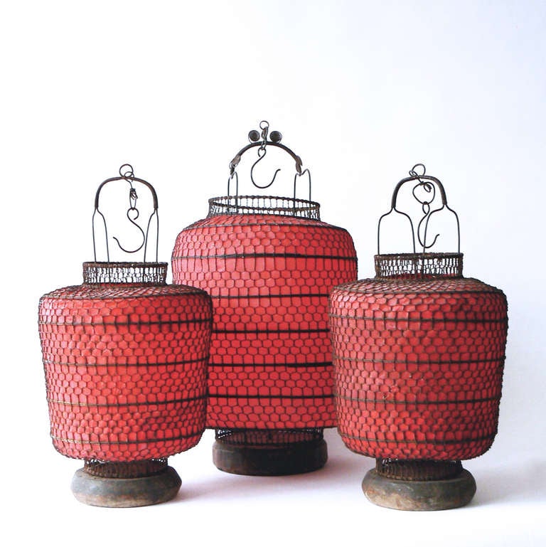 This 19th century trio still have their original paper. They have wooden bases for candles, or they could be easily converted for electric use. Price is for the set, though we will also sell them individually. The larger lantern is 31