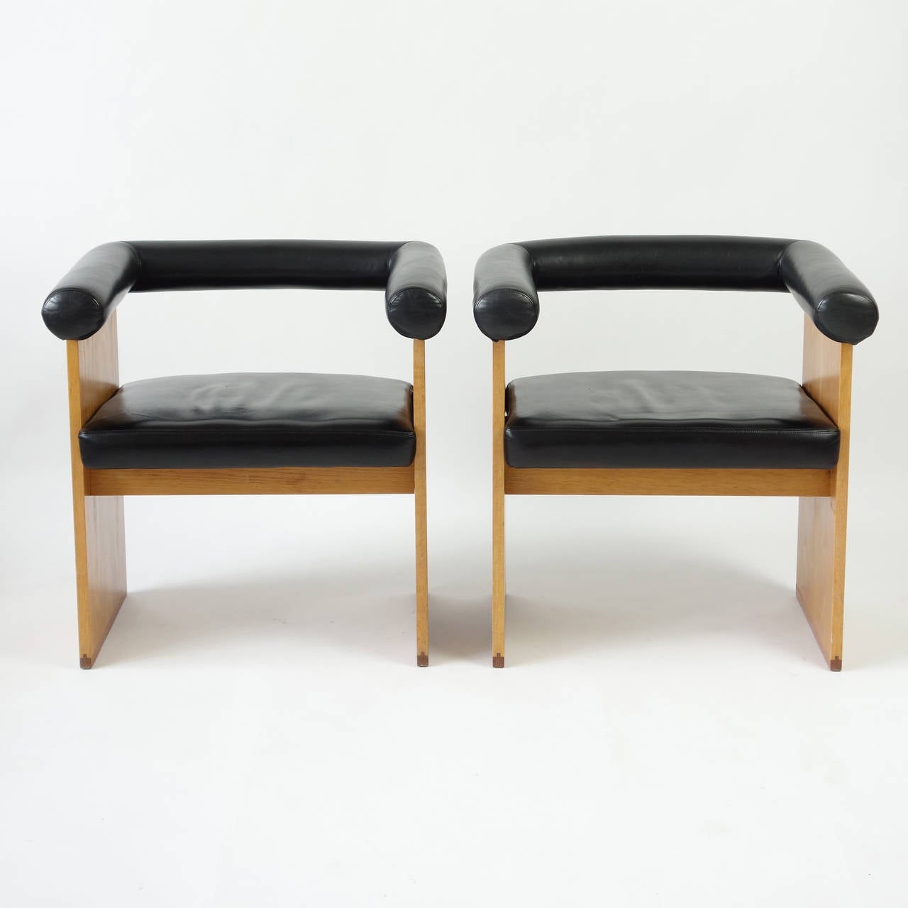 These chairs have the starkly planar quality of Donald Judd's furniture, and the tubular padded leather arms and backrests bring to mind functionalist designs of the 1920s and 1930s. Liming brings out the lovely symmetry in the grain of the oak.