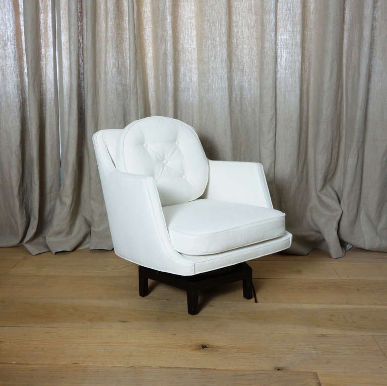 A 1960s Dunbar swivel armchair designed by Edward Wormley. The base is ebonized mahogany. The back cushion is filled with a mix of goose feathers and down. Recently reupholstered in an ivory chenille.