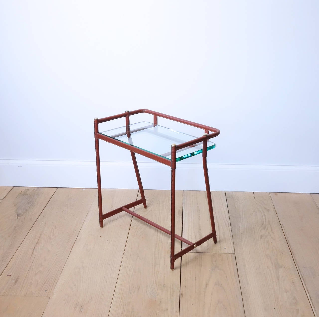 A stylish side table, perfect for mail and keys or a small bar. The leather is original, and has aged well. Glass is new.