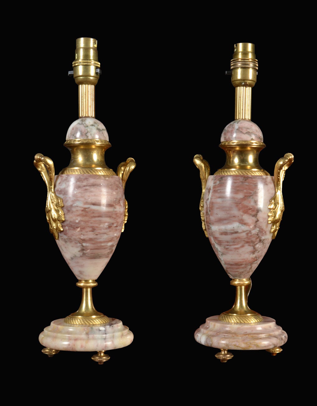 Pair of gilt metal mounted veined marble mantel lamps Of urn form, having foliated mounts on circular stepped bases
(the lamps have been re-wired)