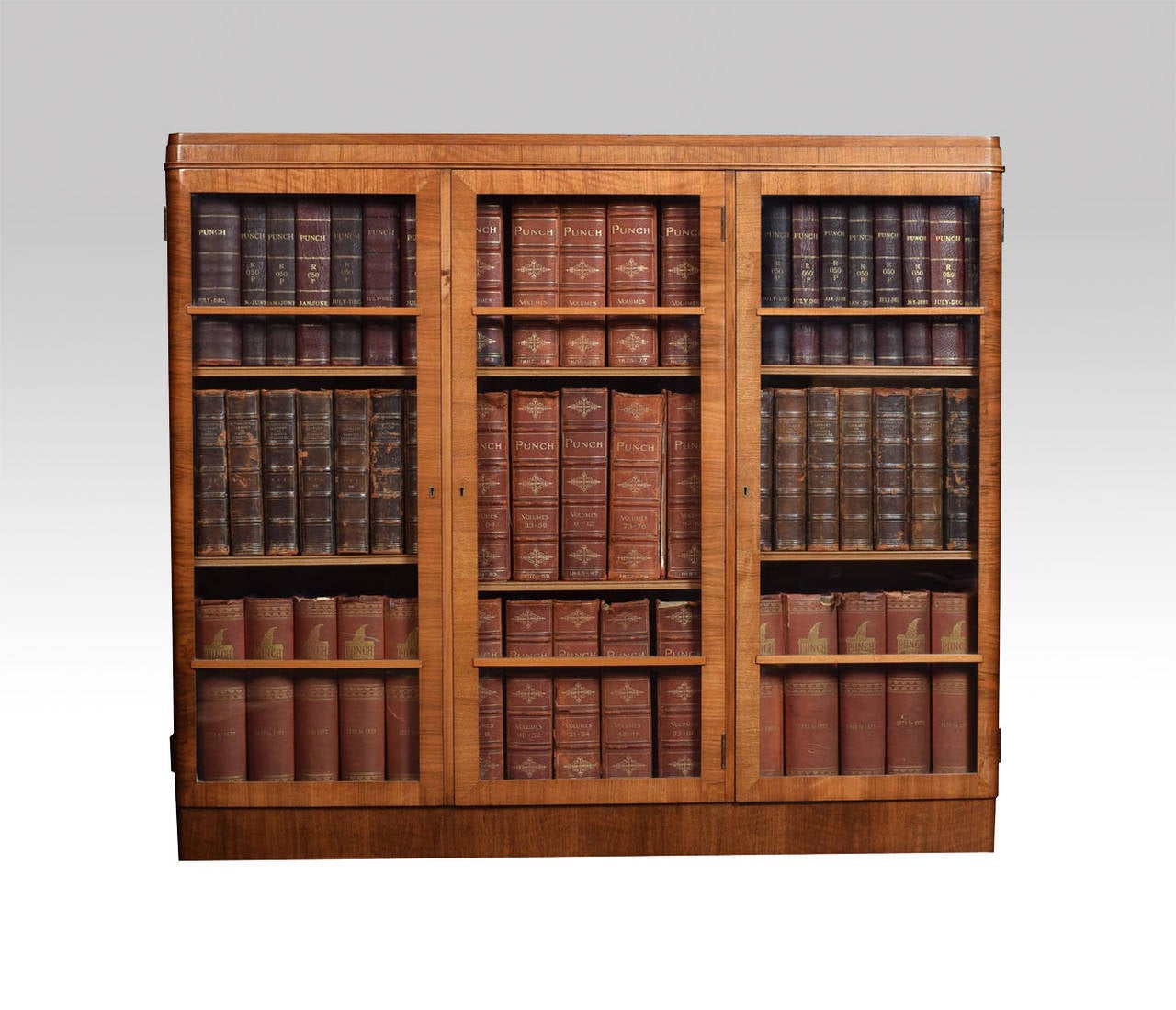 Art deco walnut bookcase the rectangular top with rounded corners above three glazed doors opening to reveal two adjustable shelves to each section all raised up on plinth base

Dimensions

Height 42.5 Inches

Width 48.5 Inches

Depth 12