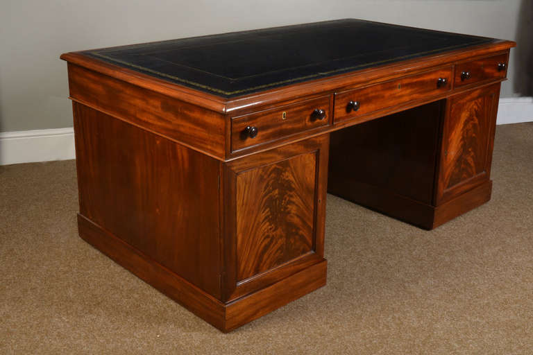 large Victorian mahogany partners desk the rectangular blue hide top with a gilt-tooled  border enclosed by a moulded edge over an arrangement of three drawers above two large cupboards surrounding the central kneehole, open to reveal three short