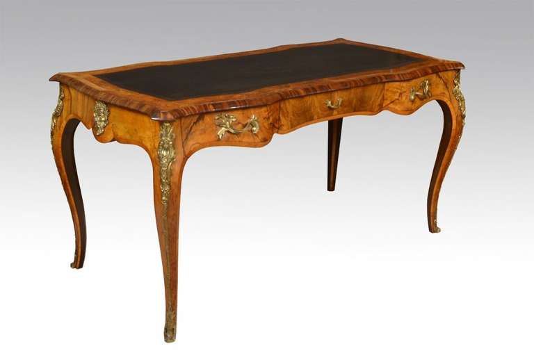 Figured walnut, kingwood, tulipwood gilt bronze mounted bureau Plat of serpentine form having inset black leather writing surface with tooled border above three draws with foliated handles all raised up on four gilt bronze mounted cabriole legs