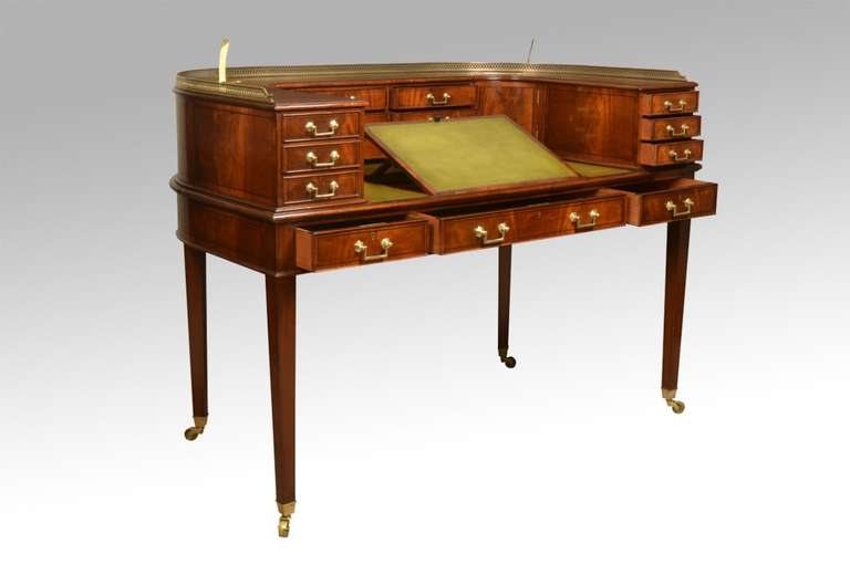 Mahogany Carlton house desk in the George III style,the rear superstructure having raised gallery above a pair of brass mounted letter apertures, incorporating drawers and a pair of cupboards, the ratchet adjustable green tooled leather writing