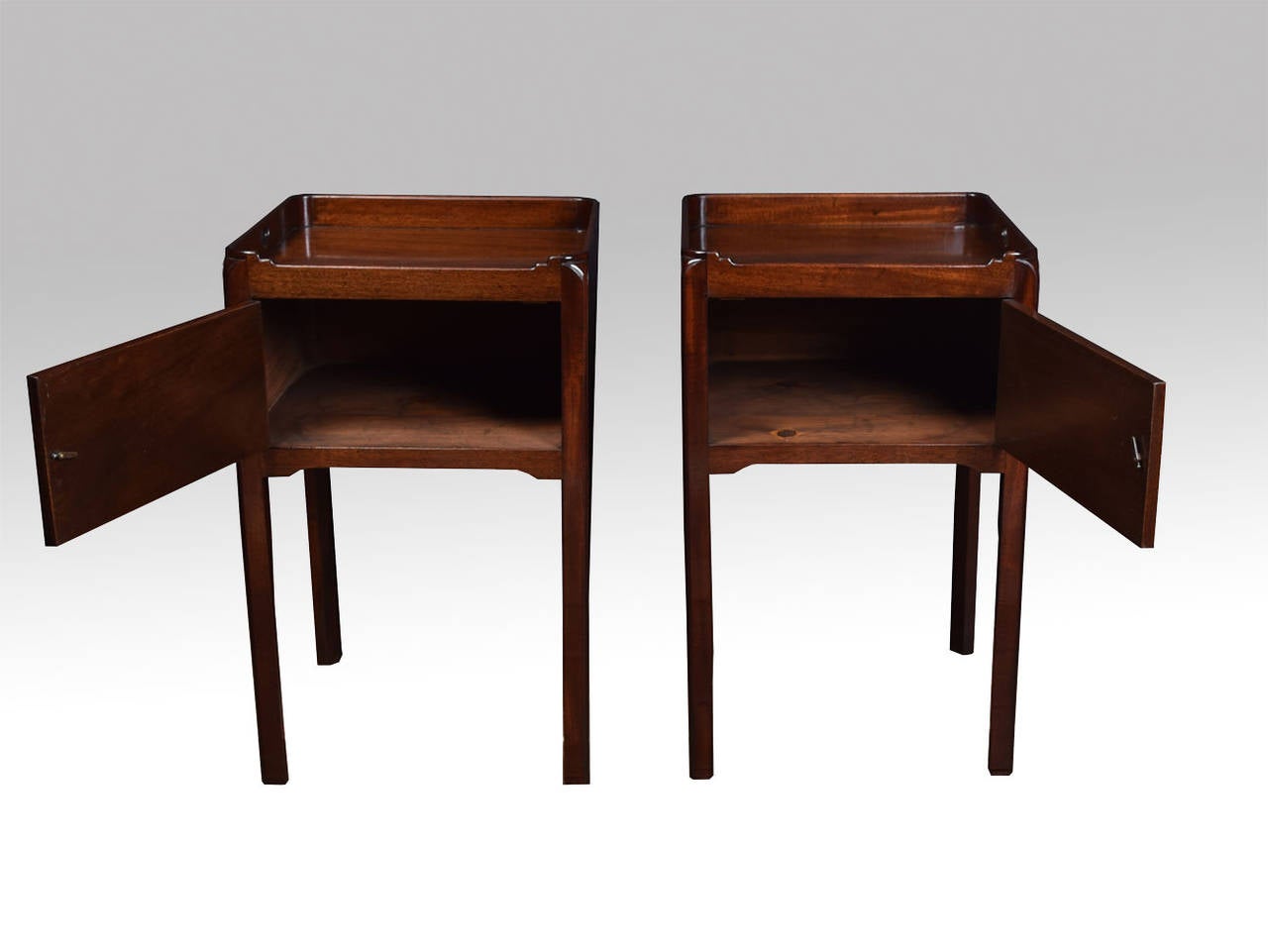 Pair of George III style mahogany bedside cupboards each with tray tops, above a single door on chamfered square legs
Height 30.5 Inches
Width 18.5 Inches
Depth 17 Inches