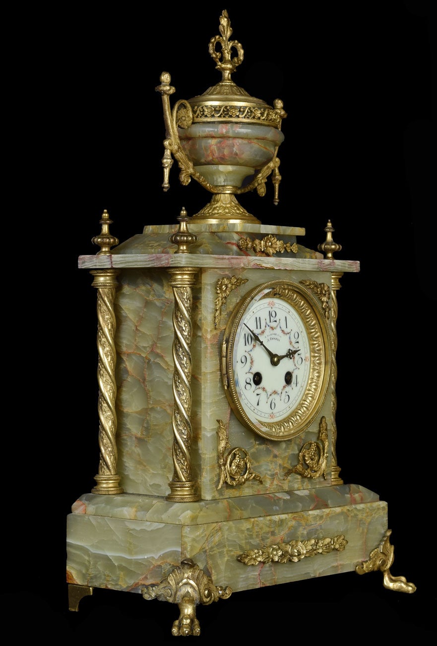 19th century French onyx and gilt metal clock set, the painted dial with Arabic numerals and the movement marked `A. Chapus, Paris, A La Gerbe D`Or, Rue de Rivoli, the clock case surmounted with  urn above architectural case with columns and raised