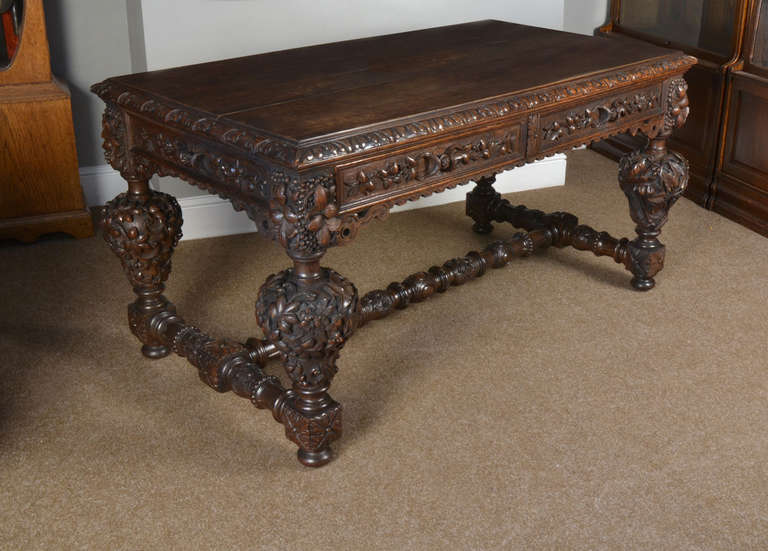 Victorian oak library or centre table the large rectangular top with moulded edge to the carved freeze with foliage, having two frieze drawers and opposing dummys, on turned and carved legs with concealed castors,