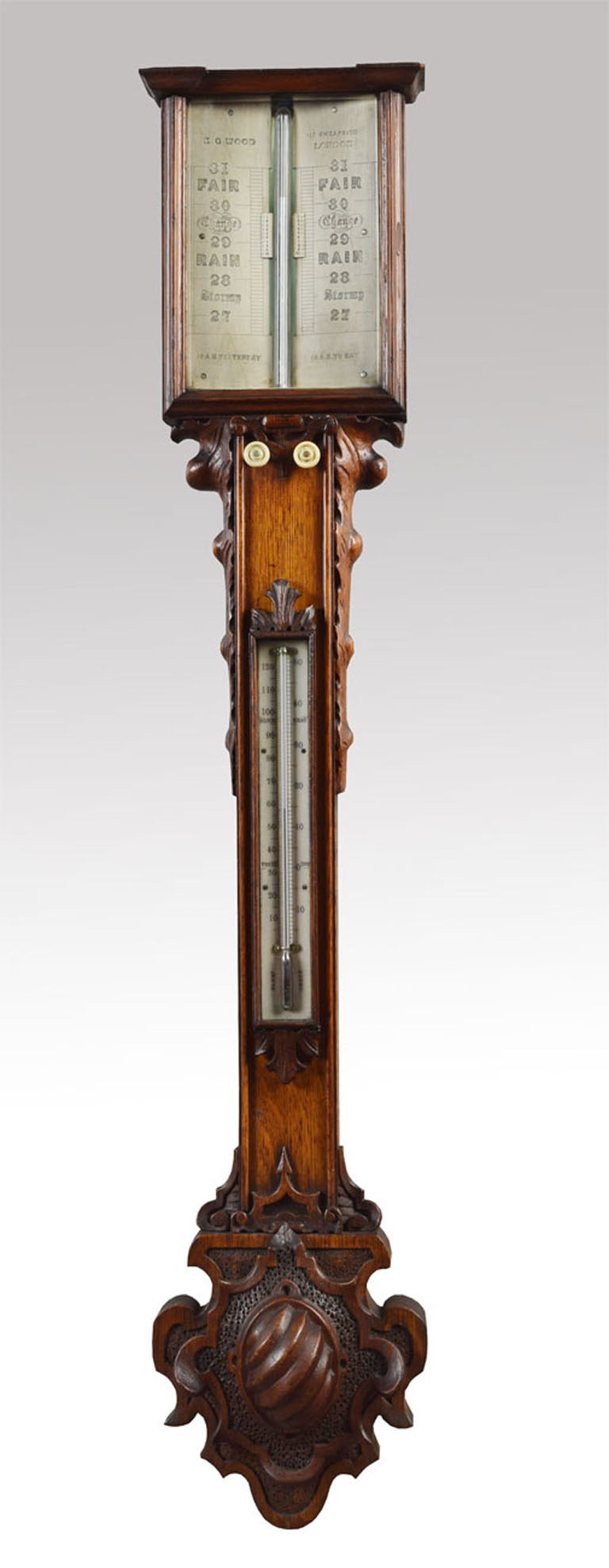 Victorian oak cased stick barometer and thermometer ‘E.G. Wood, 117 Cheapside, London’  with engraved ivory scales contained in case carved with flowers and leafage and with moulded pediment, scrolled side brackets and shaped cistern