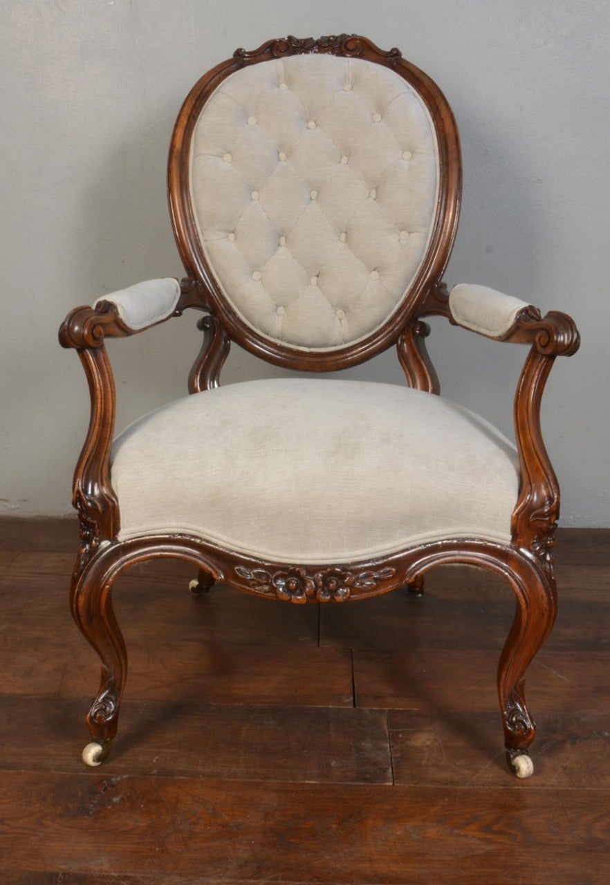 Victorian ladies armchair, having a walnut balloon shaped show frame with deep buttoned backs. The overstuffed arms having carved knuckles and swept supports, raised on cabriole front supports terminating in ceramic castor's

Dimensions

Height