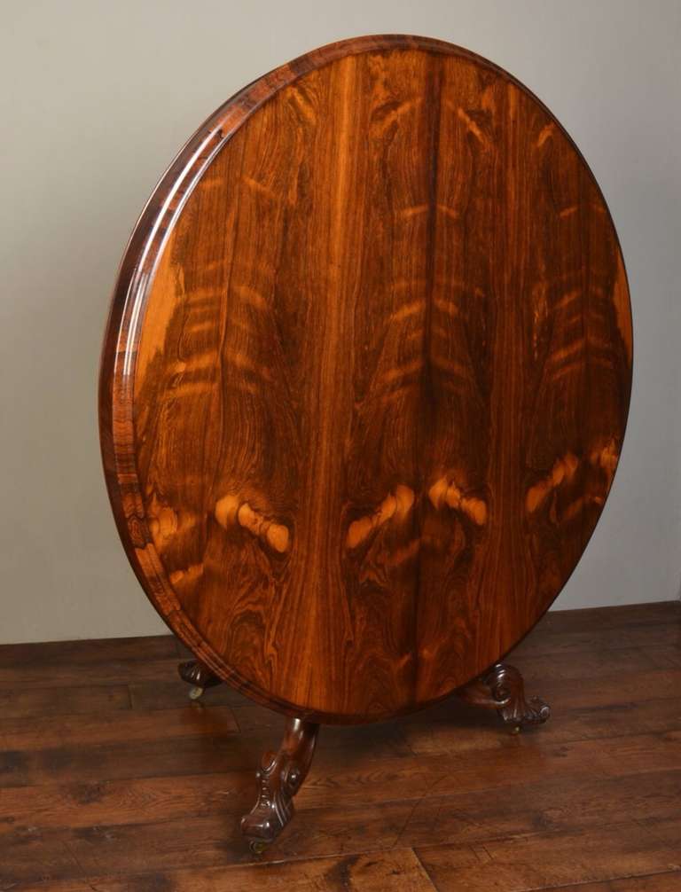 Victorian rosewood breakfast table, the large circular top with moulded edge above the pedestal base with moulded column on scroll carved cabriole legs.