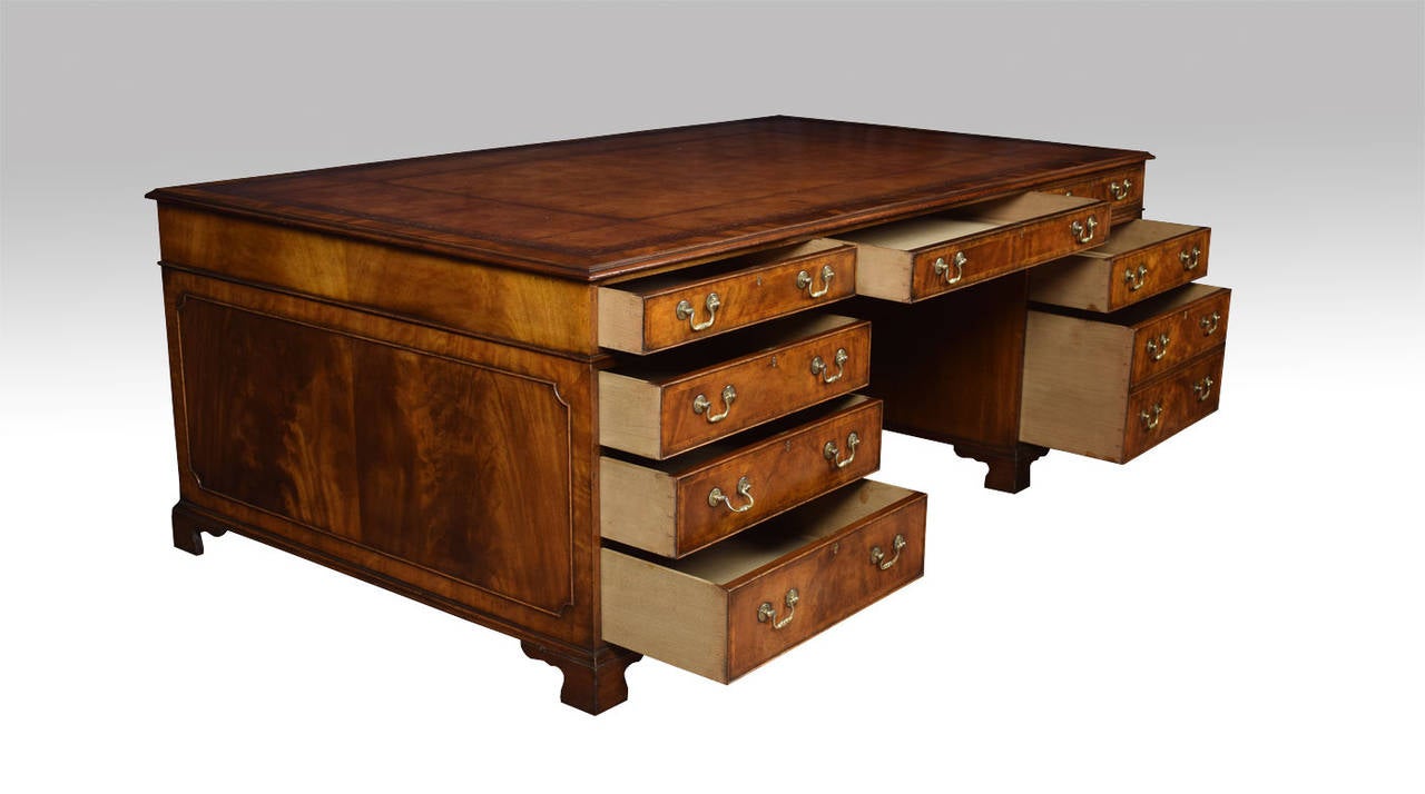 Very large mahogany partners desk the rectangular brown hide top with a gilt-tooled border enclosed by a moulded edge over an arrangement of three drawers above two large pedestals having three draws to one side the other one single and one double