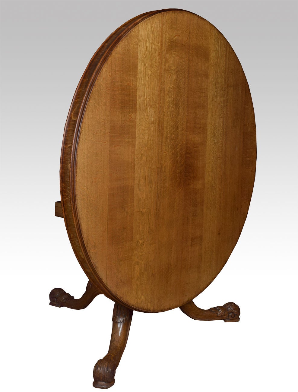 Oak round dining or center table, the circular top above pedestal base with gothic carved panels all raised up on acanthus scroll legs terminating in brass castors. Stamped Gillows Lancaster.

Dimensions: Height 29
Diameter 56.5 Inches