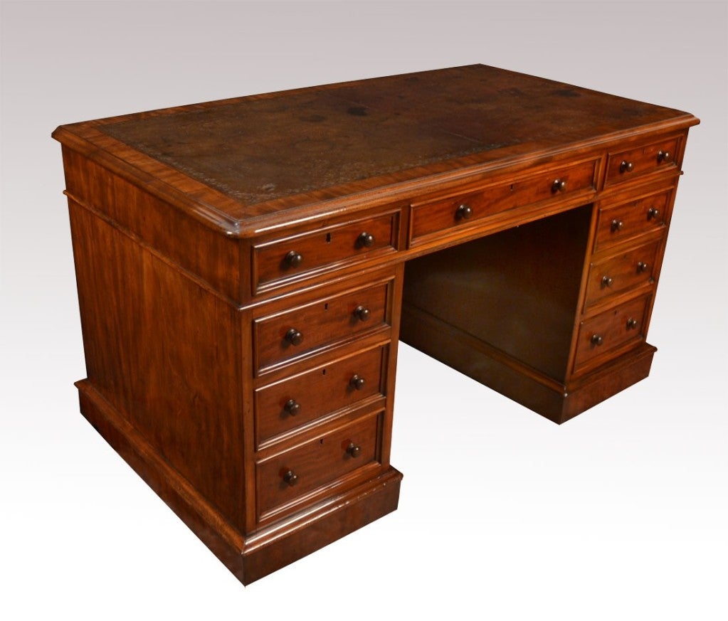 Victorian mahogany partners desk the original  rectangular brown hide top with a tooled  border enclosed by a moulded edge over an arrangement of three drawers above two large pedestals having three draws to each side surrounding the central knee